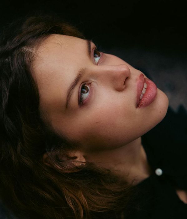 Woman with a calm and focused look, cyan light emphasizing her eyes.